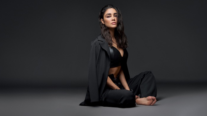 Woman in black suit sitting on floor