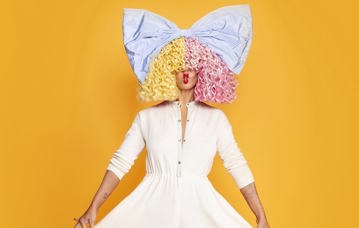 Sia with large bow and colorful wig