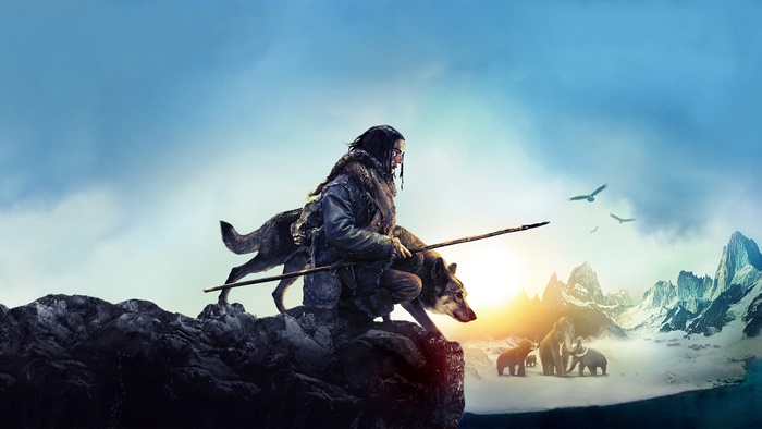 Man and wolf on a cliff with mammoths and mountains