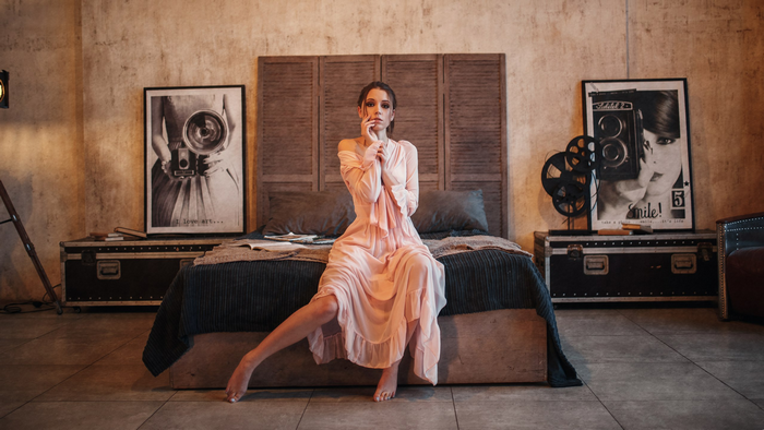Ksenia Kokoreva on a bed with vintage decor
