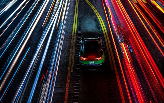 Green Porsche 911 on a highway at night
