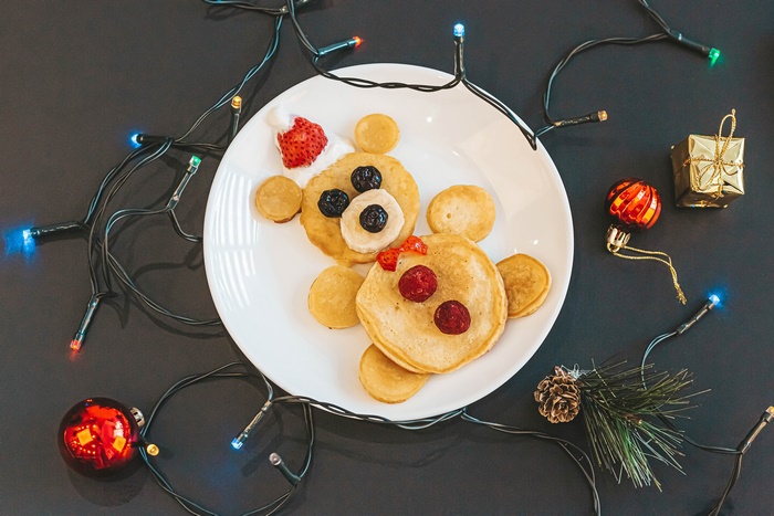Bear-shaped pancakes with berries and Christmas lights