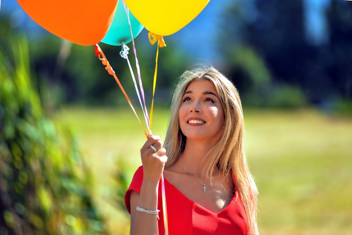 Woman holding balloons outdoors