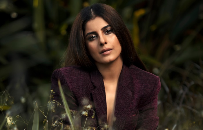 Isha Talwar in a maroon blazer outdoors