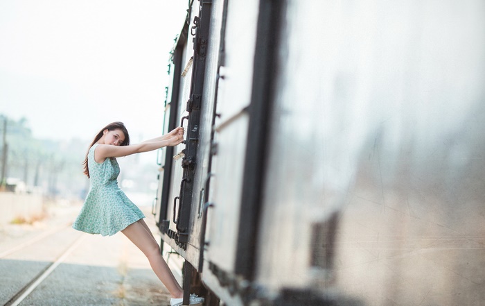 Woman in dress hanging onto train