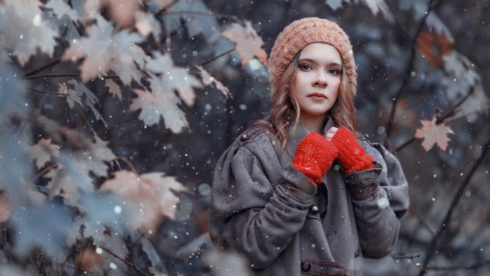 Woman wearing a hat and red mittens