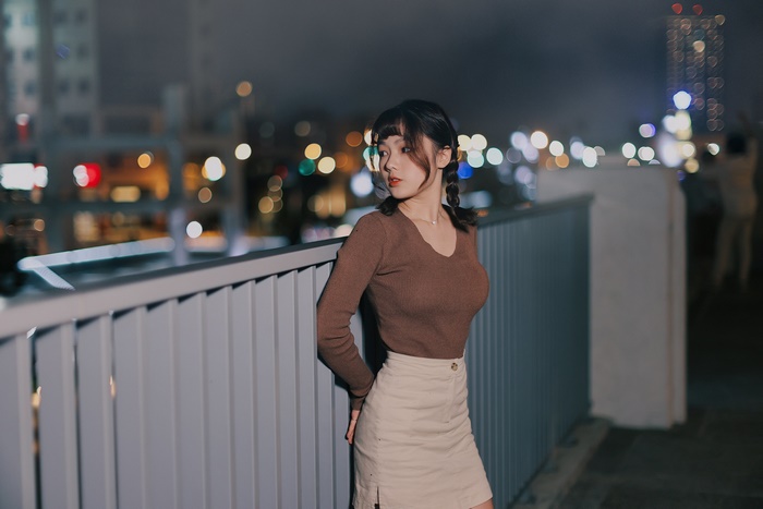 Asian woman with black hair in brown top and skirt
