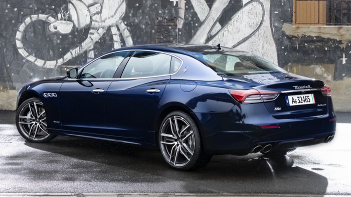 Blue Maserati Quattroporte GranLusso parked in front of graffiti wall