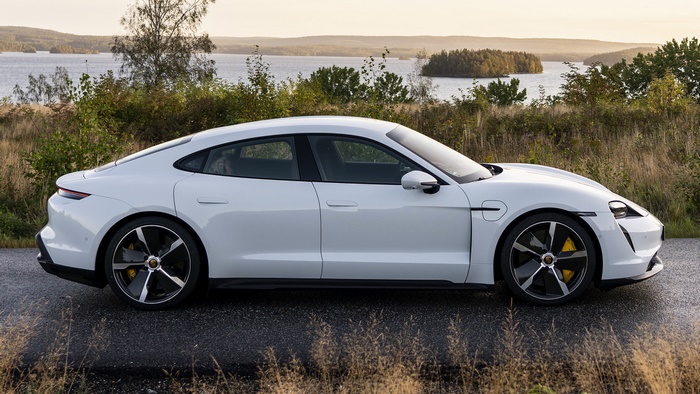 White Porsche Taycan Turbo S parked by a lake