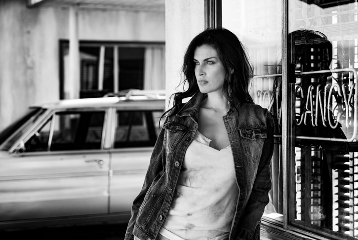Woman in denim jacket standing by a window