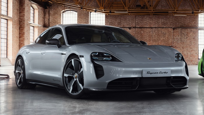 Silver Porsche Taycan Turbo electric sedan in a brick building