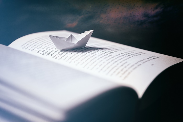 Origami paper boat on an open book