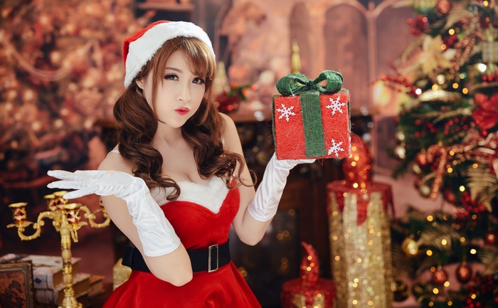 Woman in Santa costume holding a Christmas gift