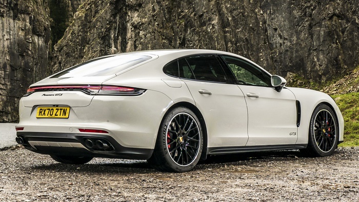 White Porsche Panamera GTS parked on gravel near rocks
