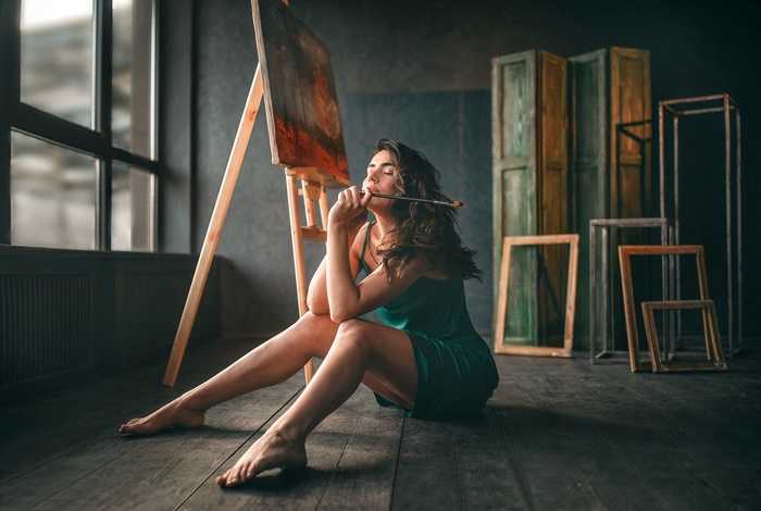 Woman in Green Dress Sitting Near Easel