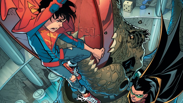 Superboy and Robin fighting a dinosaur