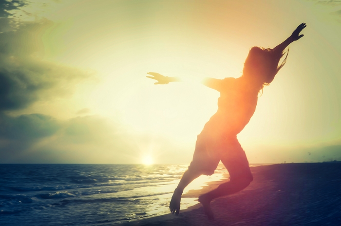 Person jumping on a beach at sunset