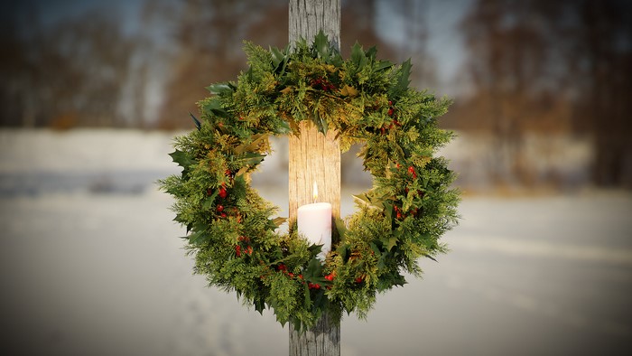 Christmas wreath with candle on wooden post