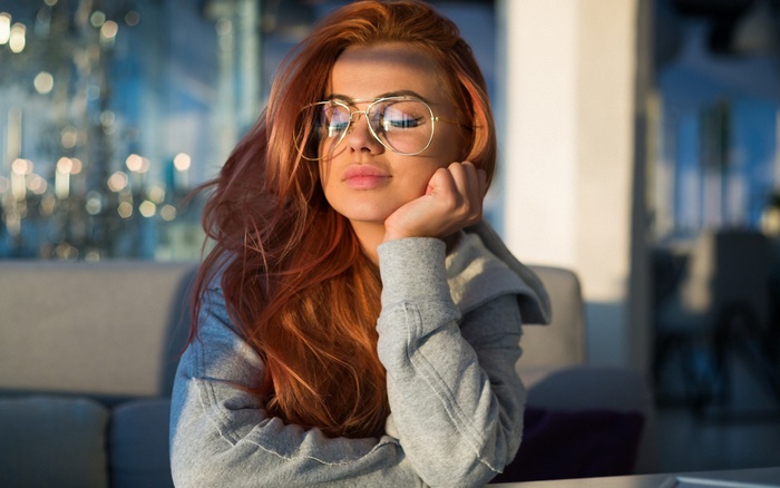 Woman with red hair wearing glasses