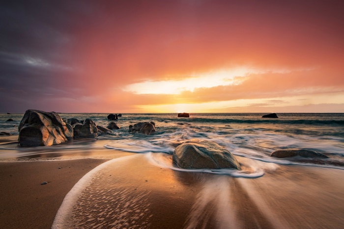 Ocean sunset over a rocky beach with waves