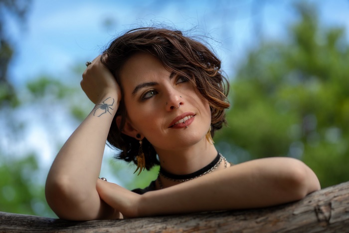 Woman with spider tattoo and piercings outdoors