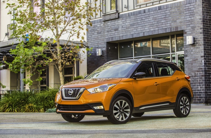 Orange Nissan Kicks SUV parked outside building