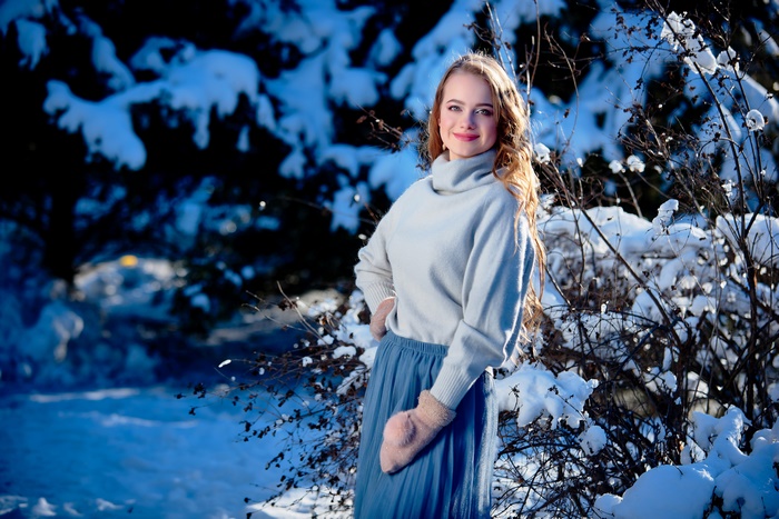 Woman in winter clothing with snow-covered trees