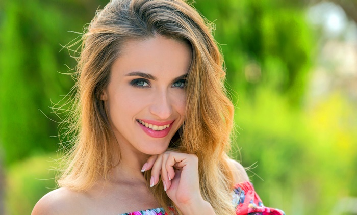 Woman with blonde hair and blue eyes smiling