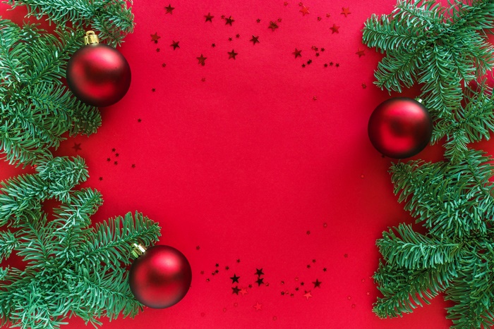 Christmas tree branches with red ornaments and stars
