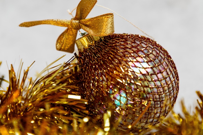 Golden Christmas ornament with bow and tinsel