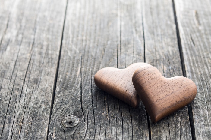 Two wooden hearts on a rustic wooden surface