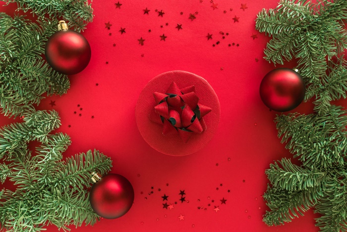 Christmas ornaments and gift box on red background