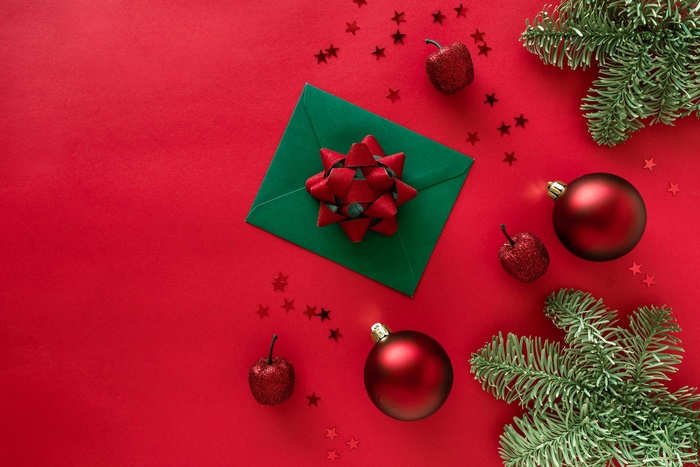 Christmas ornaments and fir branches on red background