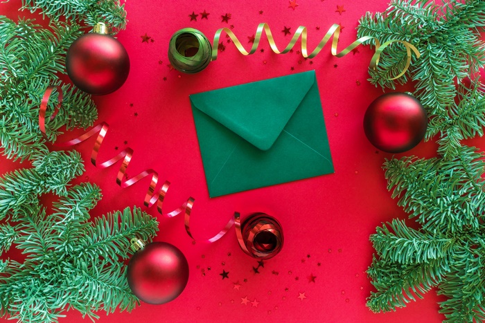 Christmas ornaments and fir branches on red background