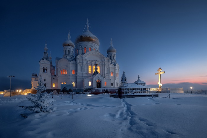 White Monastery in Snow at Dusk with Large Cross