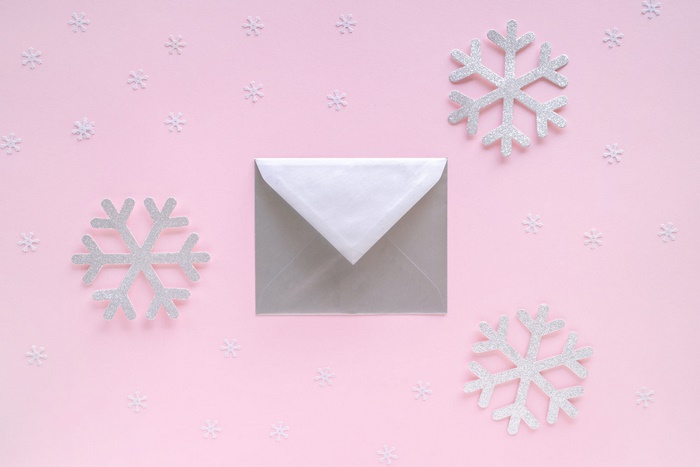 Silver snowflakes and envelope on pink background