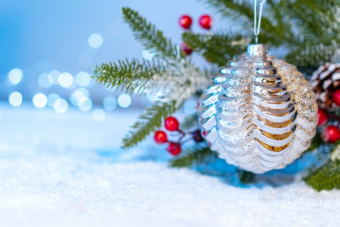 Christmas ornament on a snowy branch with bokeh lights