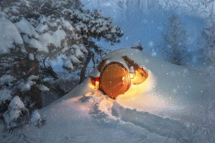 Snowy hobbit hole with glowing lanterns