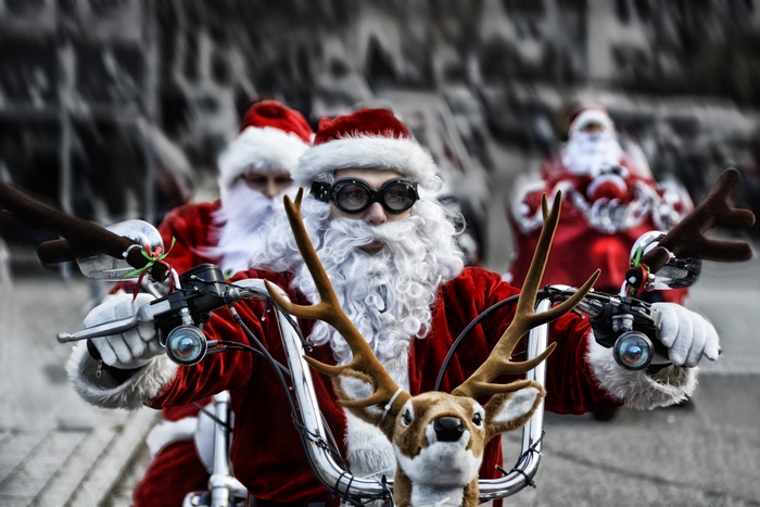 Three bikers dressed as Santa Claus on motorcycles