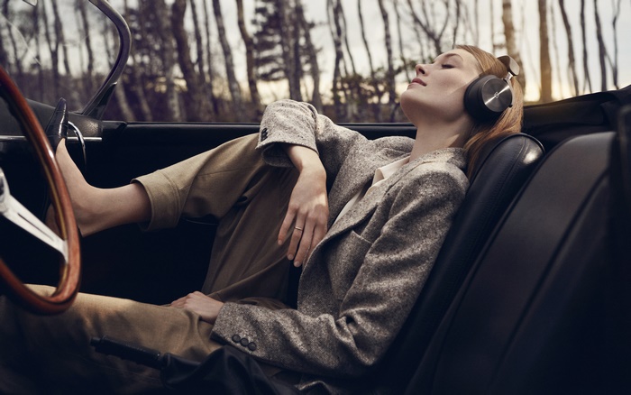 Woman wearing headphones in a convertible car
