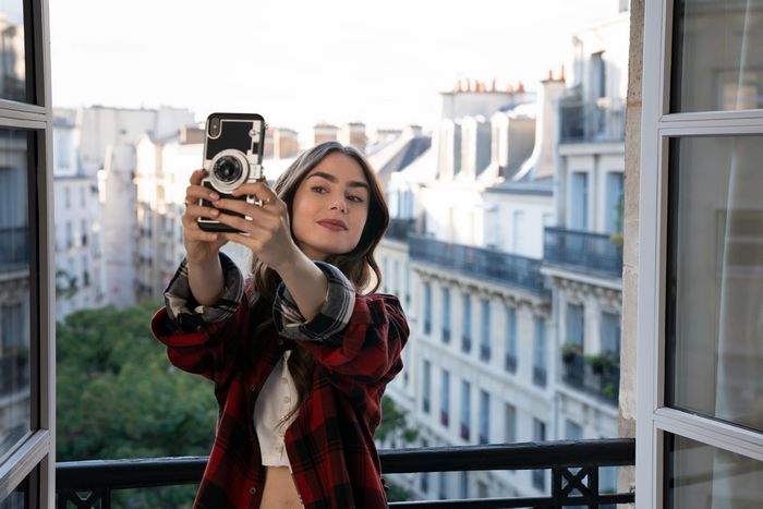 Lily Collins taking a selfie with a camera phone