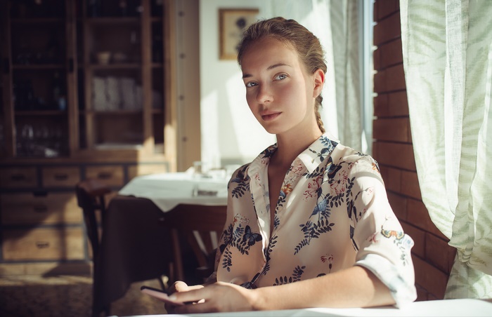 Woman sitting at a table with a phone