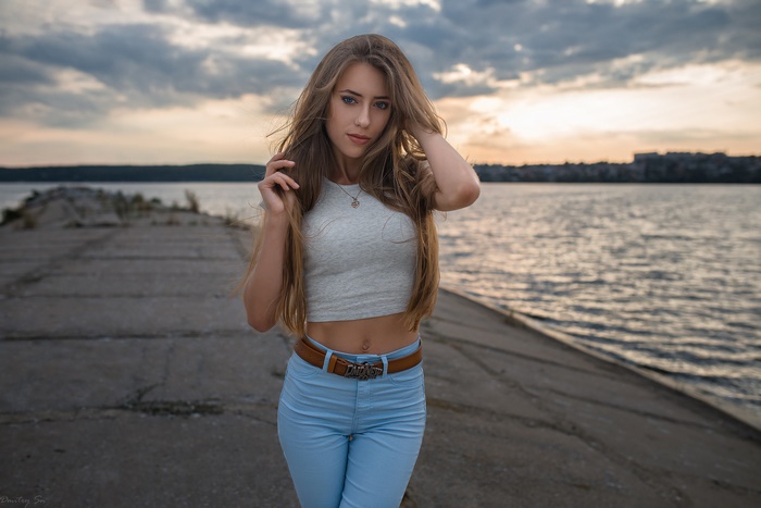 Woman with long blonde hair and blue eyes on a pier