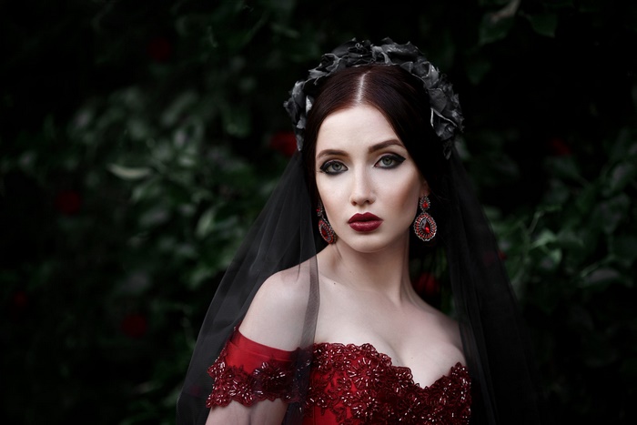 Veiled Woman in Red Dress with Dark Floral Headpiece