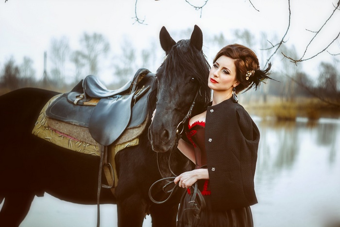 Woman with black horse and saddle