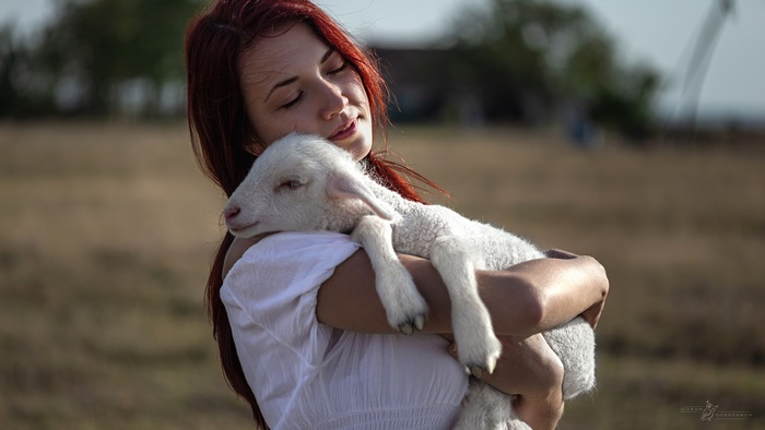 Redhead woman holding a lamb