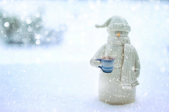 Snowman holding a mug of hot chocolate in the snow