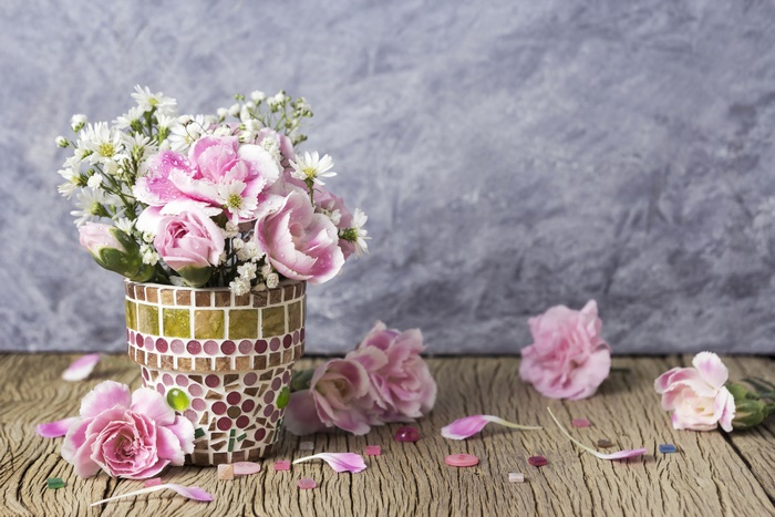 Pink carnations and chamomile in a mosaic pot