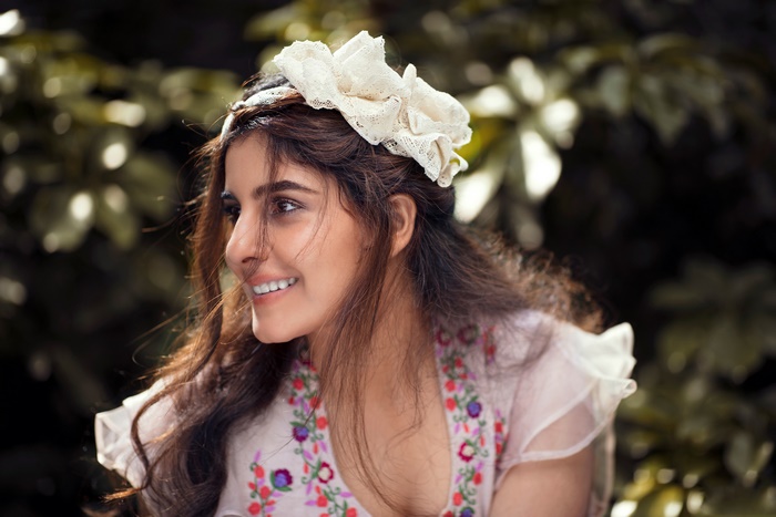 Isha Talwar smiling with a floral dress and headband