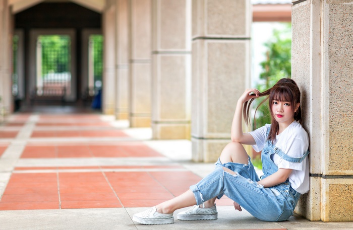 Asian woman in denim overalls and white t-shirt